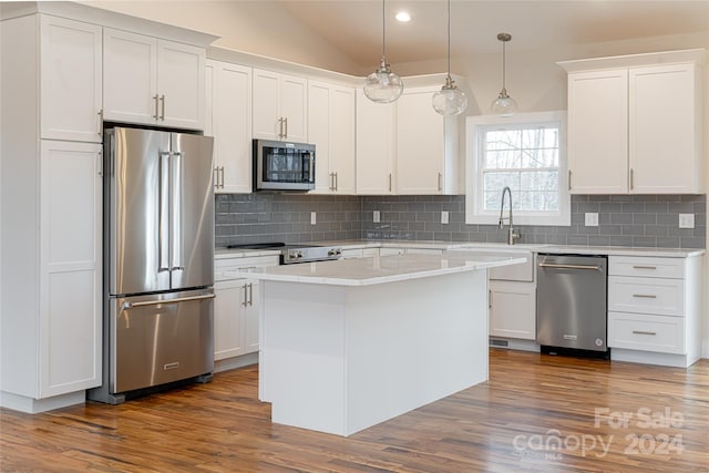 kitchen featuring appliances with stainless steel finishes, decorative light fixtures, white cabinetry, and dark wood-type flooring