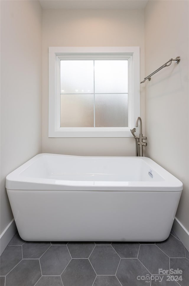 bathroom featuring tile patterned flooring and a bath