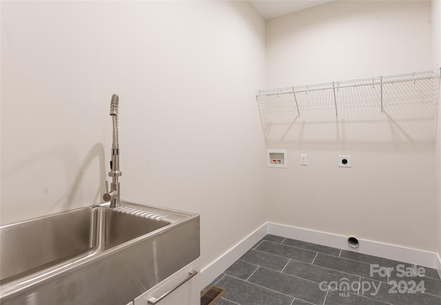 clothes washing area featuring electric dryer hookup, sink, washer hookup, and dark tile patterned flooring