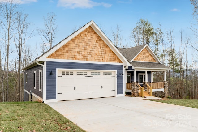 craftsman house with a porch, a garage, and a front yard