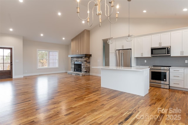 224 Country Dr, Mars Hill, NC 28754 - kitchen featuring appliances with stainless steel finishes, a center island, open floor plan, light countertops, and light wood finished floors