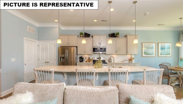 kitchen with stainless steel appliances, hanging light fixtures, sink, and a large island