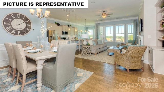 dining room with crown molding, ceiling fan with notable chandelier, and light hardwood / wood-style floors