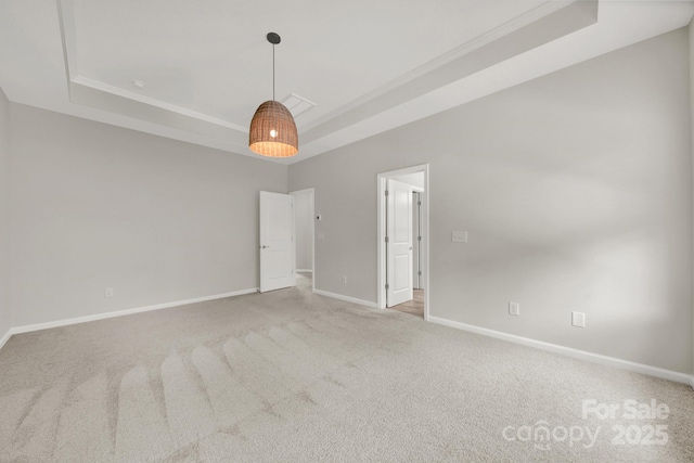 empty room featuring a raised ceiling and carpet floors