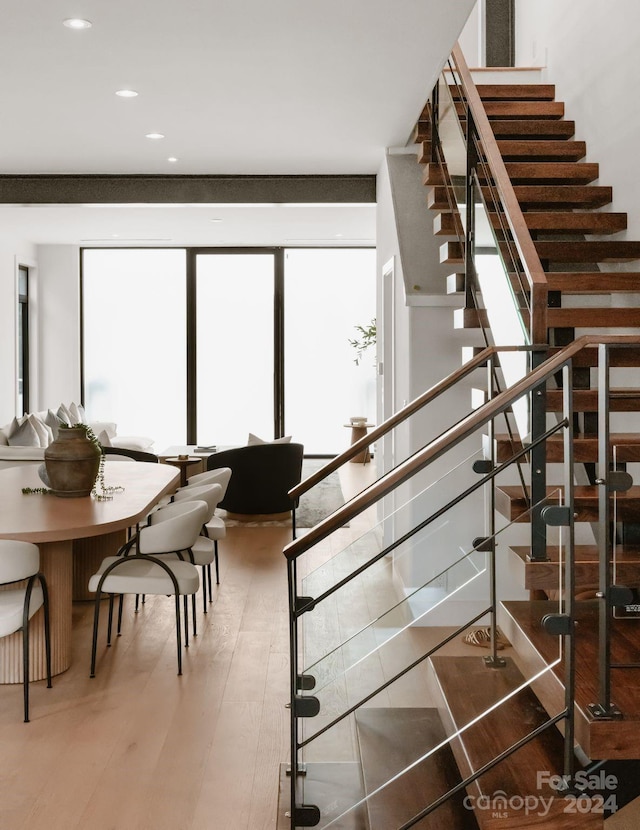 stairs featuring hardwood / wood-style floors and plenty of natural light