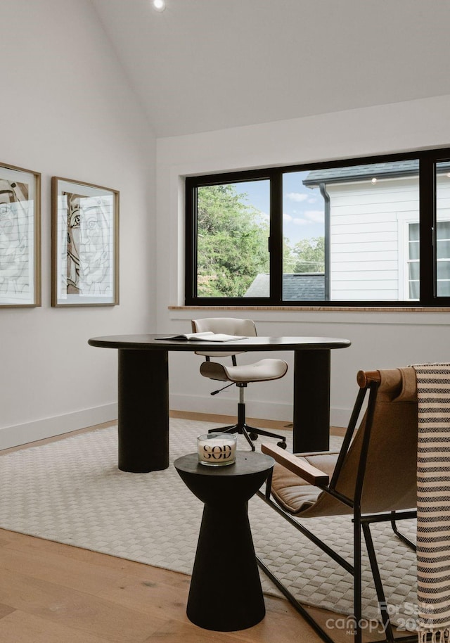 home office featuring light wood-type flooring and lofted ceiling