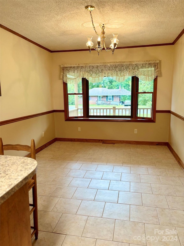 tiled empty room featuring a notable chandelier, a textured ceiling, and crown molding