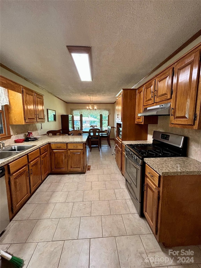 kitchen with a textured ceiling, sink, kitchen peninsula, an inviting chandelier, and stainless steel appliances