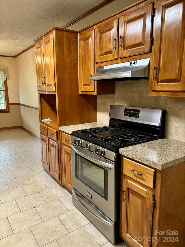 kitchen with gas stove, a textured ceiling, ornamental molding, and tasteful backsplash