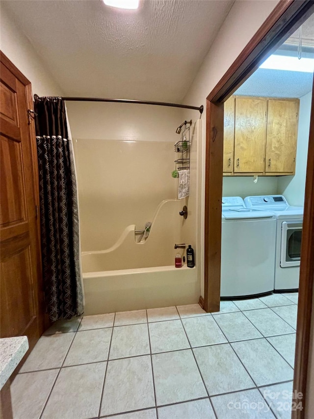 bathroom featuring a textured ceiling, independent washer and dryer, shower / bath combo with shower curtain, and tile patterned floors