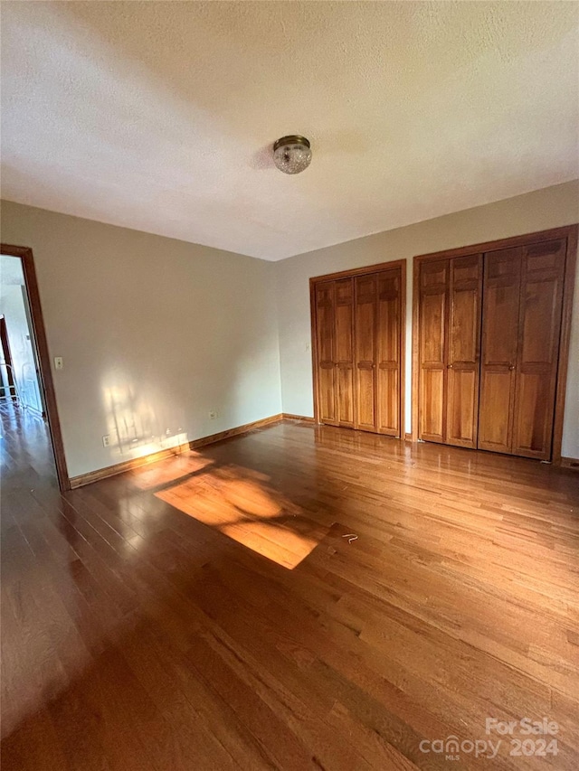 unfurnished room featuring a textured ceiling and light hardwood / wood-style flooring