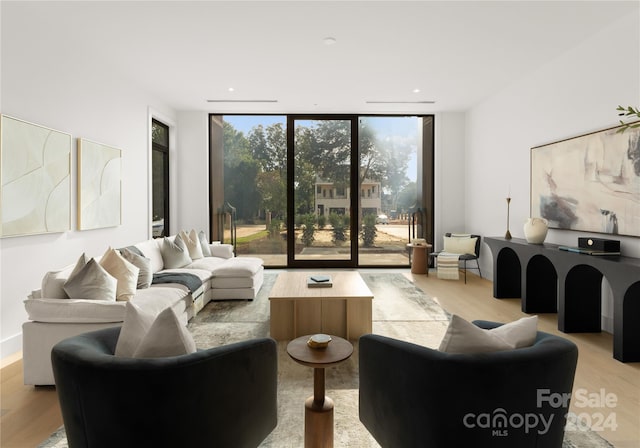 living room with expansive windows and light hardwood / wood-style floors