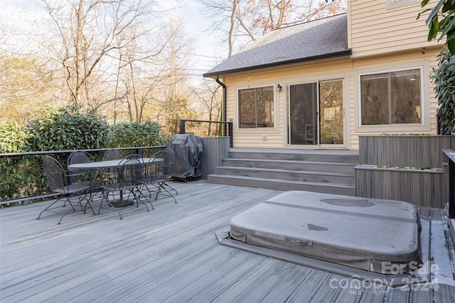 wooden deck featuring area for grilling and a covered hot tub