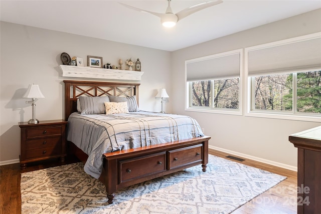 bedroom with multiple windows, light hardwood / wood-style flooring, and ceiling fan