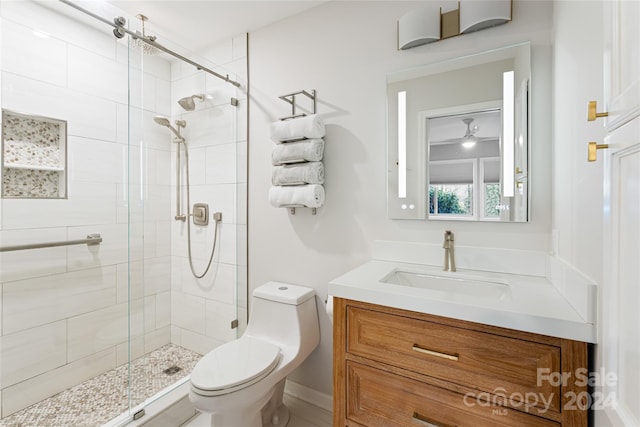 bathroom featuring vanity, toilet, and a shower with door