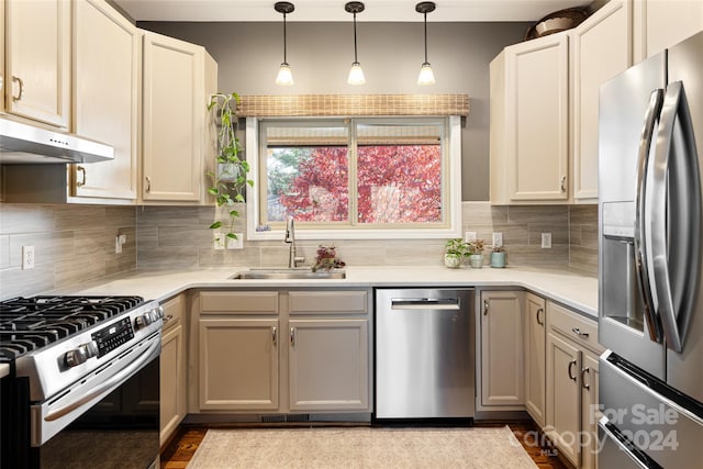 kitchen with backsplash, stainless steel appliances, hanging light fixtures, and sink