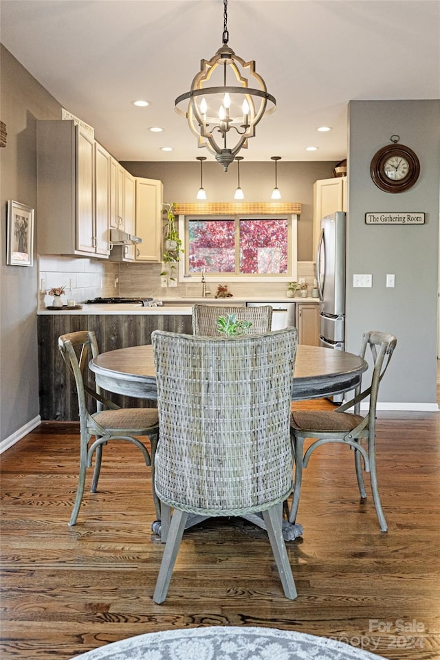 dining area featuring sink, dark hardwood / wood-style floors, and a notable chandelier