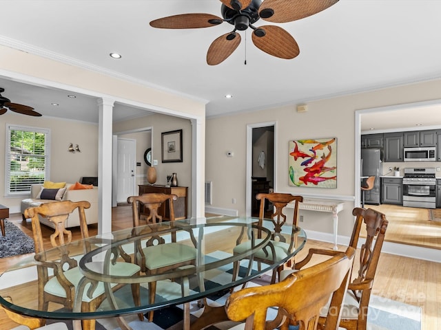 dining room with ceiling fan, light wood-type flooring, crown molding, and decorative columns