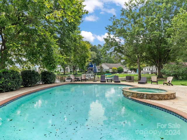 view of swimming pool with a patio and an in ground hot tub