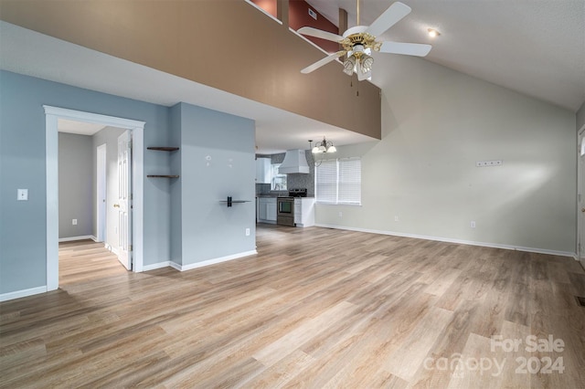 unfurnished living room with ceiling fan with notable chandelier, vaulted ceiling, and light hardwood / wood-style floors