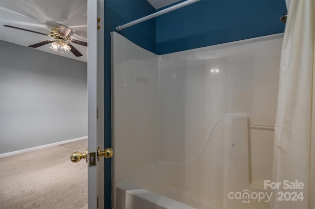 bathroom with shower / bath combination with curtain, ceiling fan, and a textured ceiling