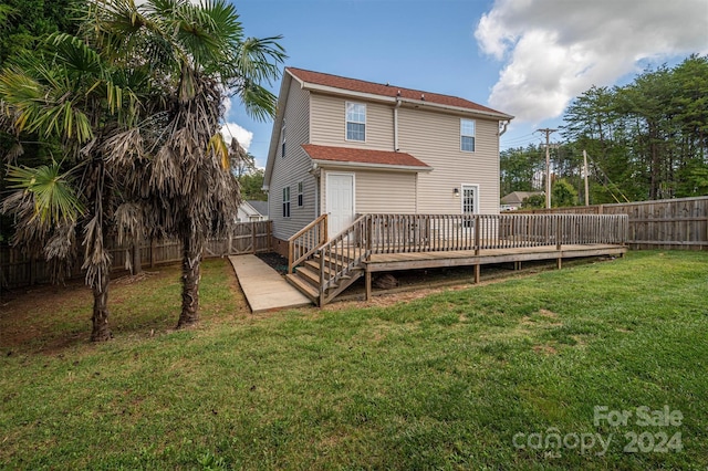 rear view of house featuring a deck and a yard