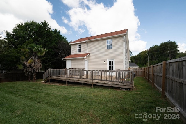 back of property featuring a yard and a wooden deck