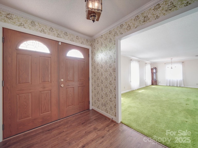 entryway featuring ornamental molding, a textured ceiling, wood-type flooring, and a wealth of natural light