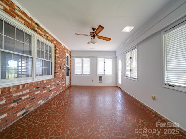 spare room with ornamental molding, brick wall, and ceiling fan