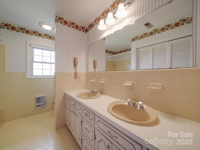 bathroom featuring heating unit, tile patterned floors, tile walls, and vanity