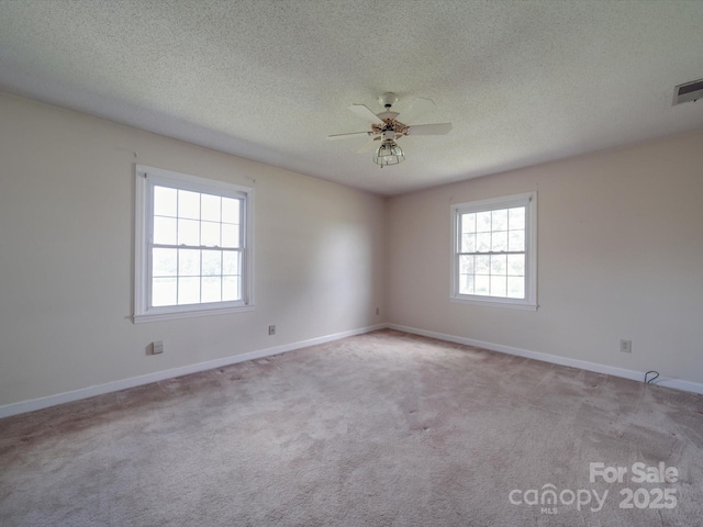 unfurnished room featuring ceiling fan, light colored carpet, and a textured ceiling