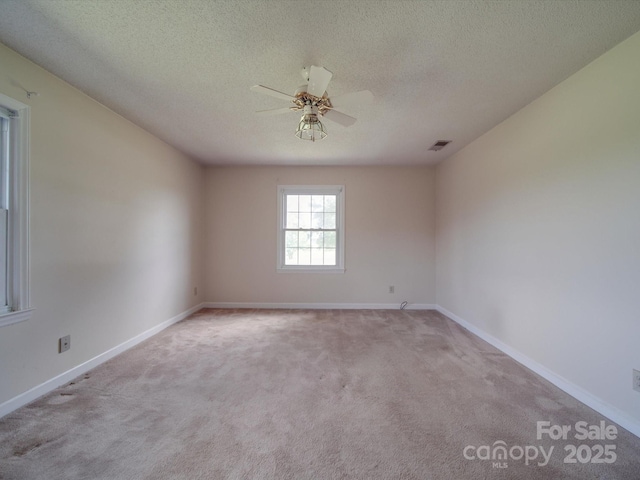 carpeted spare room featuring ceiling fan and a textured ceiling