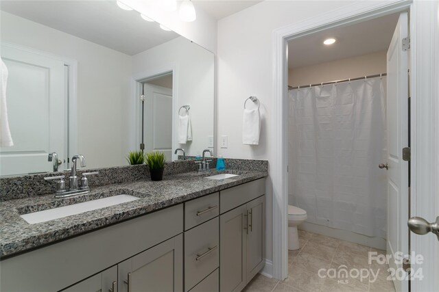 bathroom with tile patterned flooring, a shower with curtain, vanity, and toilet