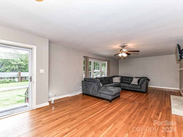 unfurnished living room featuring baseboard heating, ceiling fan, and light hardwood / wood-style flooring