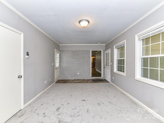 carpeted spare room featuring plenty of natural light and ornamental molding