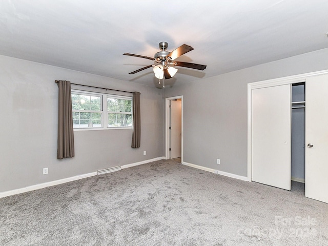 unfurnished bedroom featuring carpet flooring, ceiling fan, and a closet