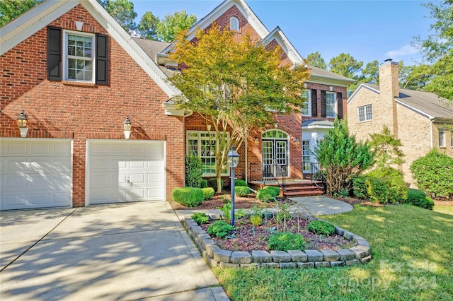 view of front of house with a garage and a front lawn