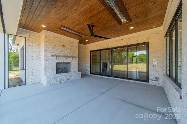 view of patio / terrace featuring an outdoor brick fireplace and ceiling fan