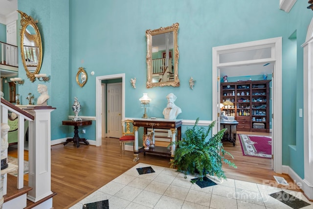 foyer featuring a towering ceiling and hardwood / wood-style flooring