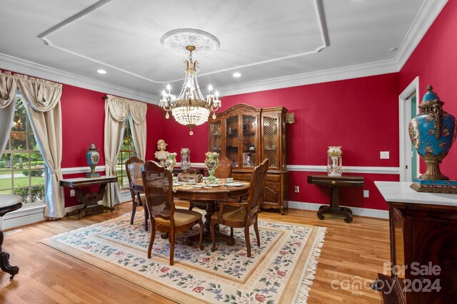 dining room featuring a notable chandelier, wood-type flooring, and crown molding