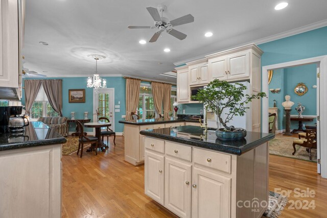 kitchen with ceiling fan with notable chandelier, a wealth of natural light, and a kitchen island