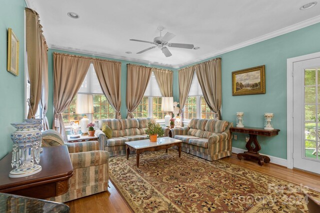 living room featuring ceiling fan, hardwood / wood-style floors, and crown molding