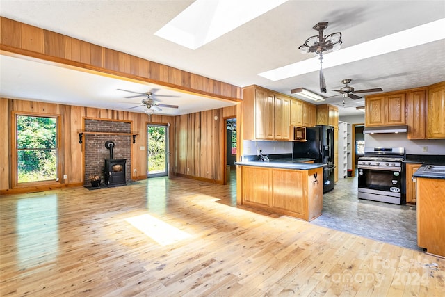 kitchen featuring ceiling fan, a skylight, and gas range