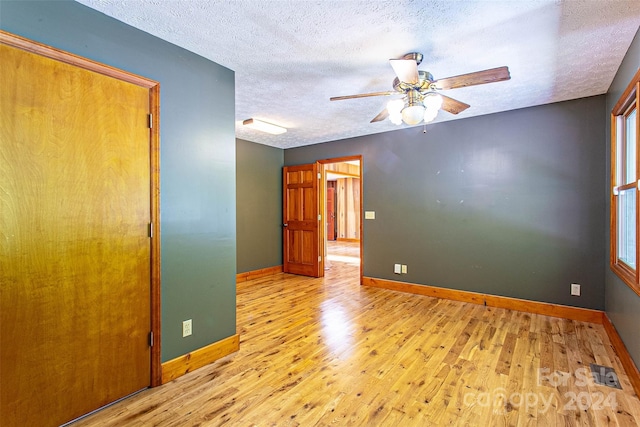 spare room with ceiling fan, a textured ceiling, and light hardwood / wood-style floors