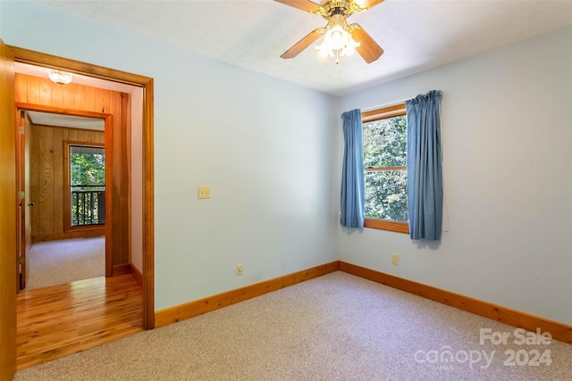 empty room with ceiling fan, plenty of natural light, and hardwood / wood-style floors