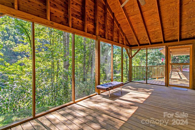 unfurnished sunroom featuring vaulted ceiling with beams