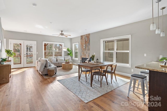 dining space with ceiling fan and light wood-type flooring