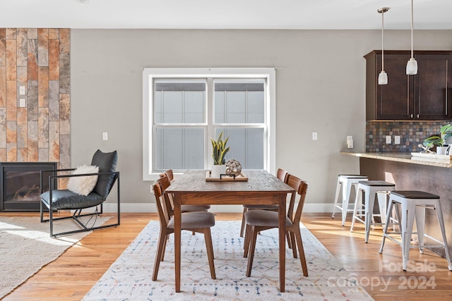 dining space featuring a fireplace and light hardwood / wood-style floors