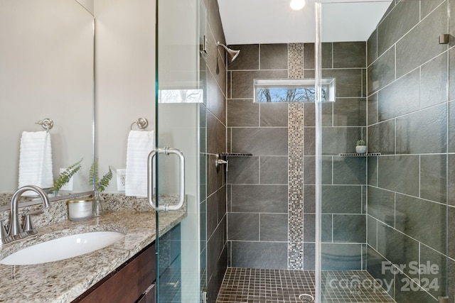 bathroom featuring vanity and a shower with shower door