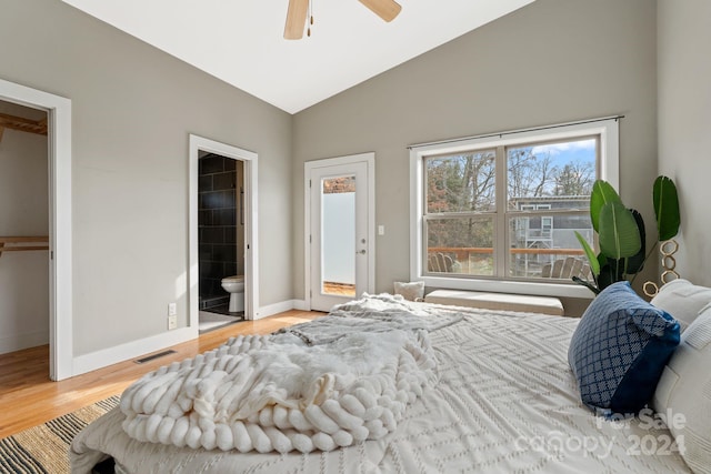 bedroom featuring ceiling fan, a spacious closet, ensuite bathroom, vaulted ceiling, and light wood-type flooring